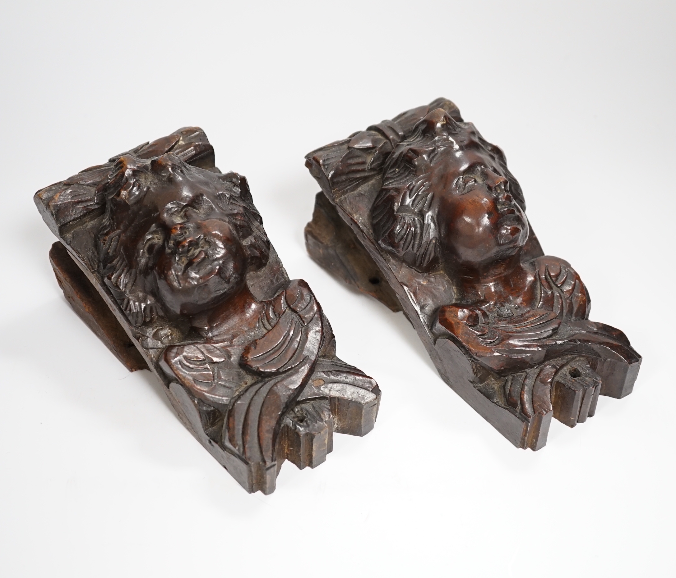 A pair of Italian carved walnut putti corbels, 18cm high